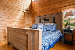 Sink into the warmth of this rustic bedroom, where knotty pine walls and natureinspired décor create a peaceful mountain retreat for your restful nights.