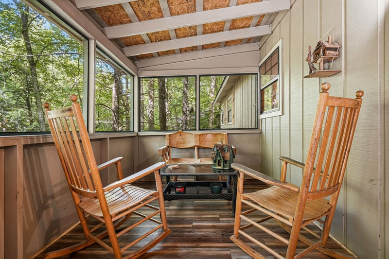 Settle into your peaceful screened porch with classic wooden rocking chairs and forest views just beyond. Its your private spot to sip morning coffee or unwind as evening falls.