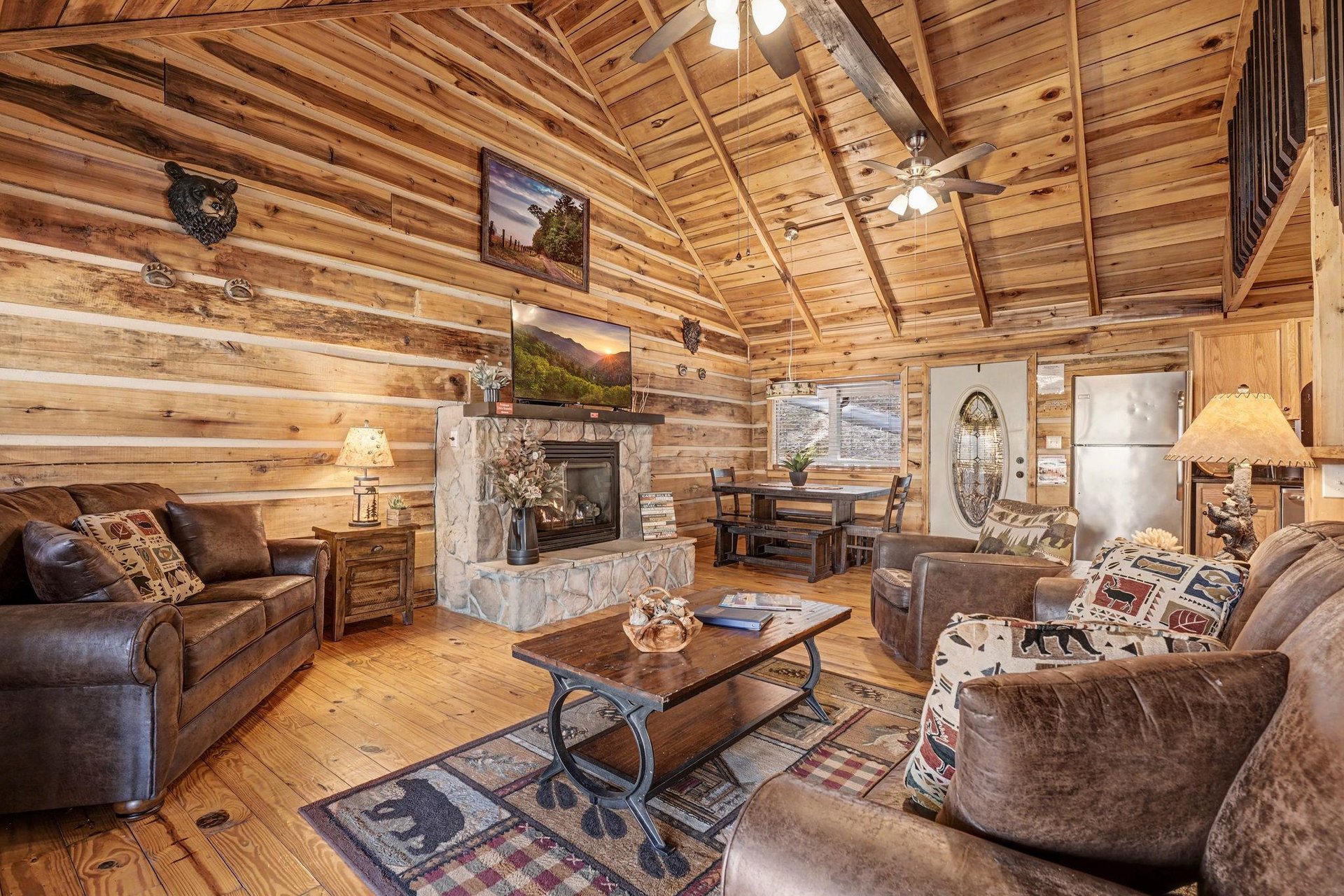 Sink into plush leather seating by your crackling stone fireplace, where rustic wood beams and cozy cabin charm create the perfect mountain retreat.