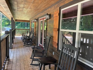Your private covered porch invites you to slow down and unwind, where rocking chairs face a peaceful, leafy neighborhood—perfect for morning coffee or evening conversation.