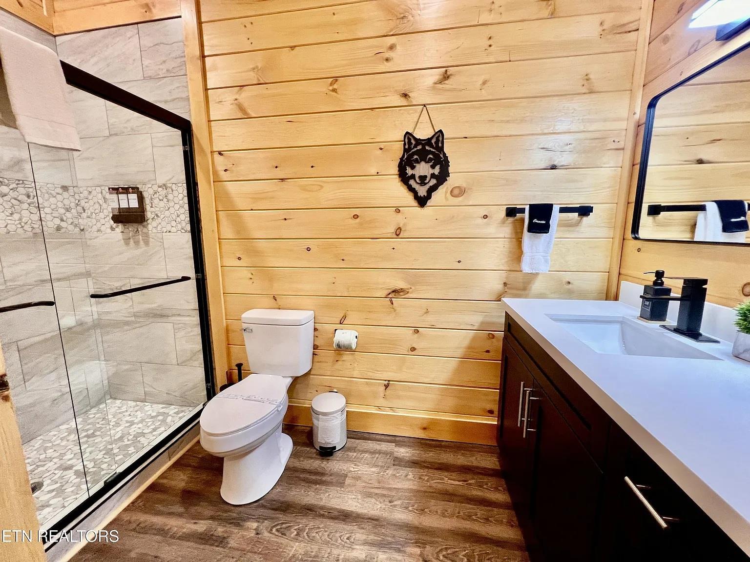 Step into your rustic bathroom featuring warm wood walls, elegant stone shower, and modern fixtures for the perfect mountain retreat feel.