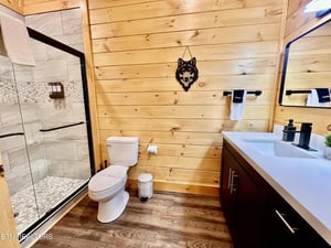 Step into your rustic bathroom featuring warm wood walls, elegant stone shower, and modern fixtures for the perfect mountain retreat feel.