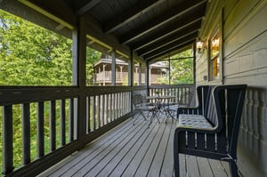 Your private covered deck invites morning coffee moments surrounded by lush treetops and peaceful cabin views.