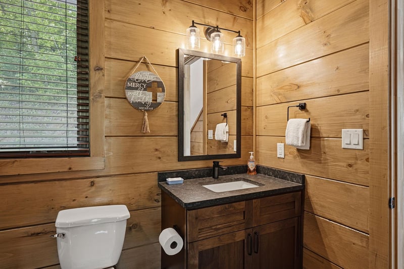 Step into your rustic bathroom where warm wood walls and modern fixtures create perfect cabin comfort for refreshing moments.