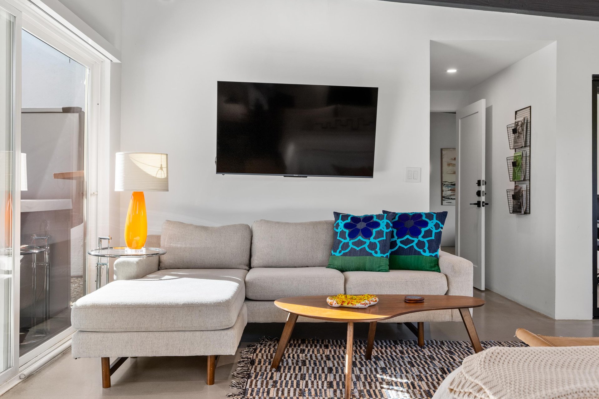 Unwind in your stylish living space featuring a plush sectional sofa, modern coffee table, and large TV for cozy evenings after exploring.