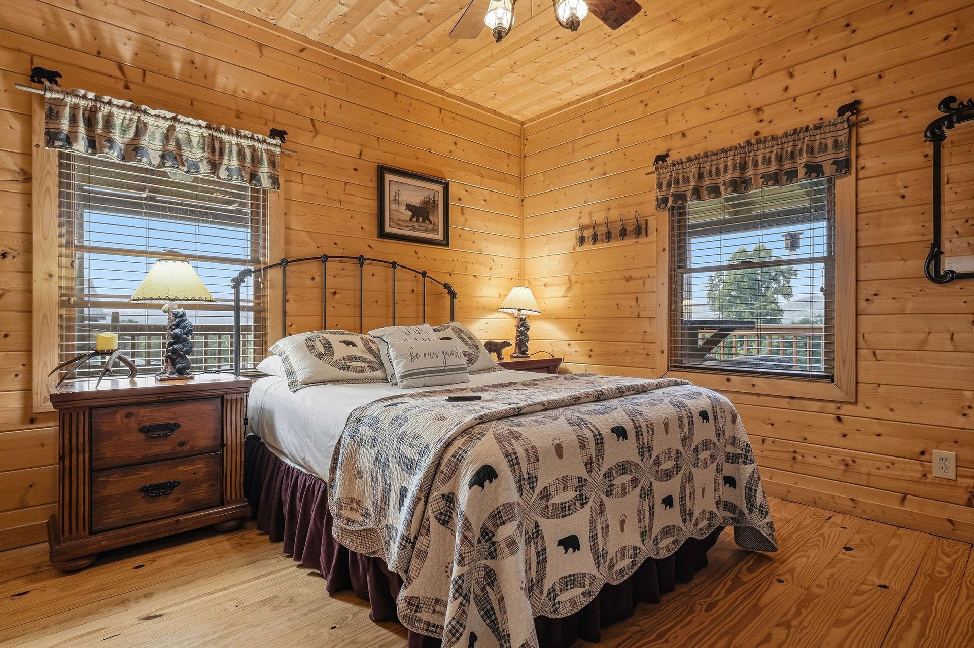 Sink into this cozy rustic bedroom with its charming pine walls and inviting bedding. Natural light fills your space through two large windows, while warm lamps create a peaceful retreat after your mo