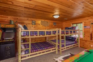 Two sets of fullsized bunk beds in the game room at Hibernation Station, a 3bedroom cabin rental located in Pigeon Forge