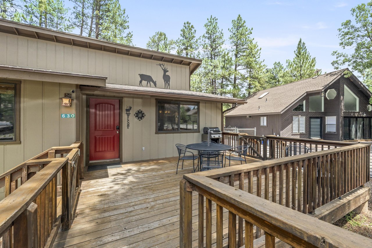Deck located at the front of the home with a BBQ, outdoor dining space, and a small firepit.