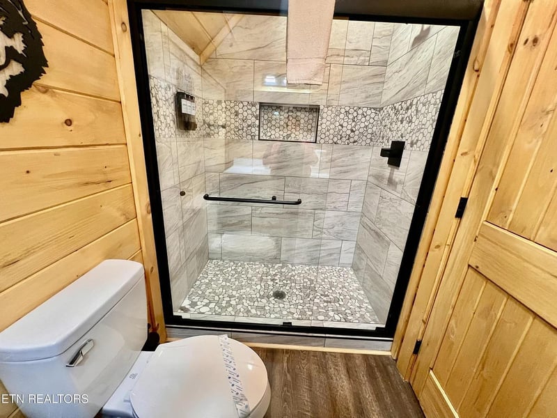 Unwind in your luxurious walkin shower featuring elegant marble tiles and stunning mosaic accents that create a spalike retreat.