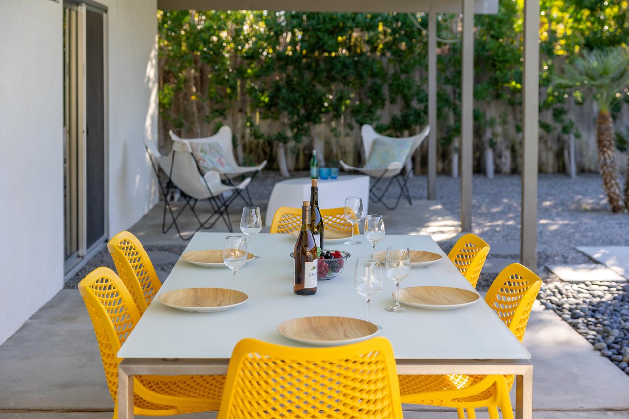 Enjoy al fresco dining on your covered terrace, where bright yellow chairs invite memorable meals under dappled shade.