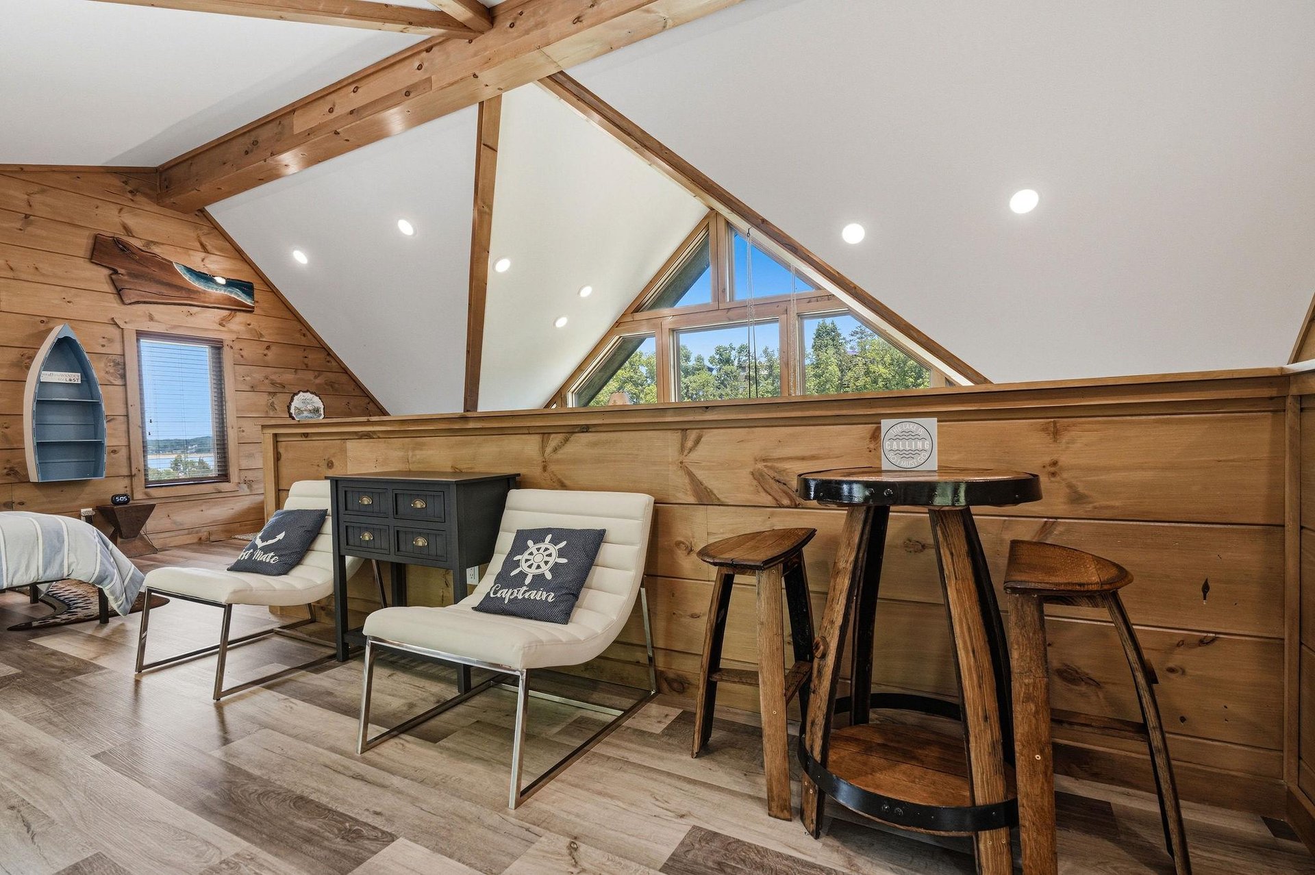 Relax in this charming loft with vaulted ceilings, warm wood beams, and cozy seating where you can unwind with lake views.