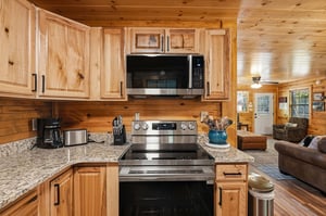 Your cabin getaway features a fullyequipped kitchen with stainless steel appliances, granite counters, and warm wood cabinetry. Cook your favorite meals while enjoying the cozy, open layout that flow