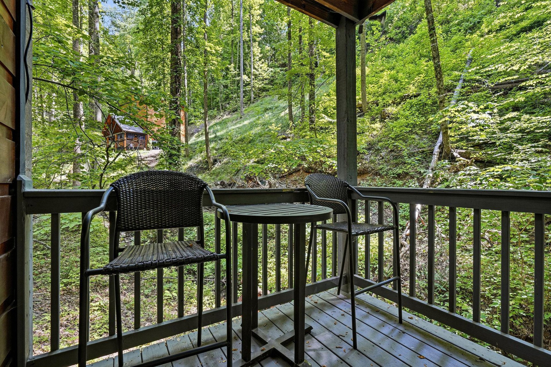 Sip morning coffee as birdsong fills the air and sunlight filters through towering trees. This cozy balcony offers your peaceful retreat into natures embrace.