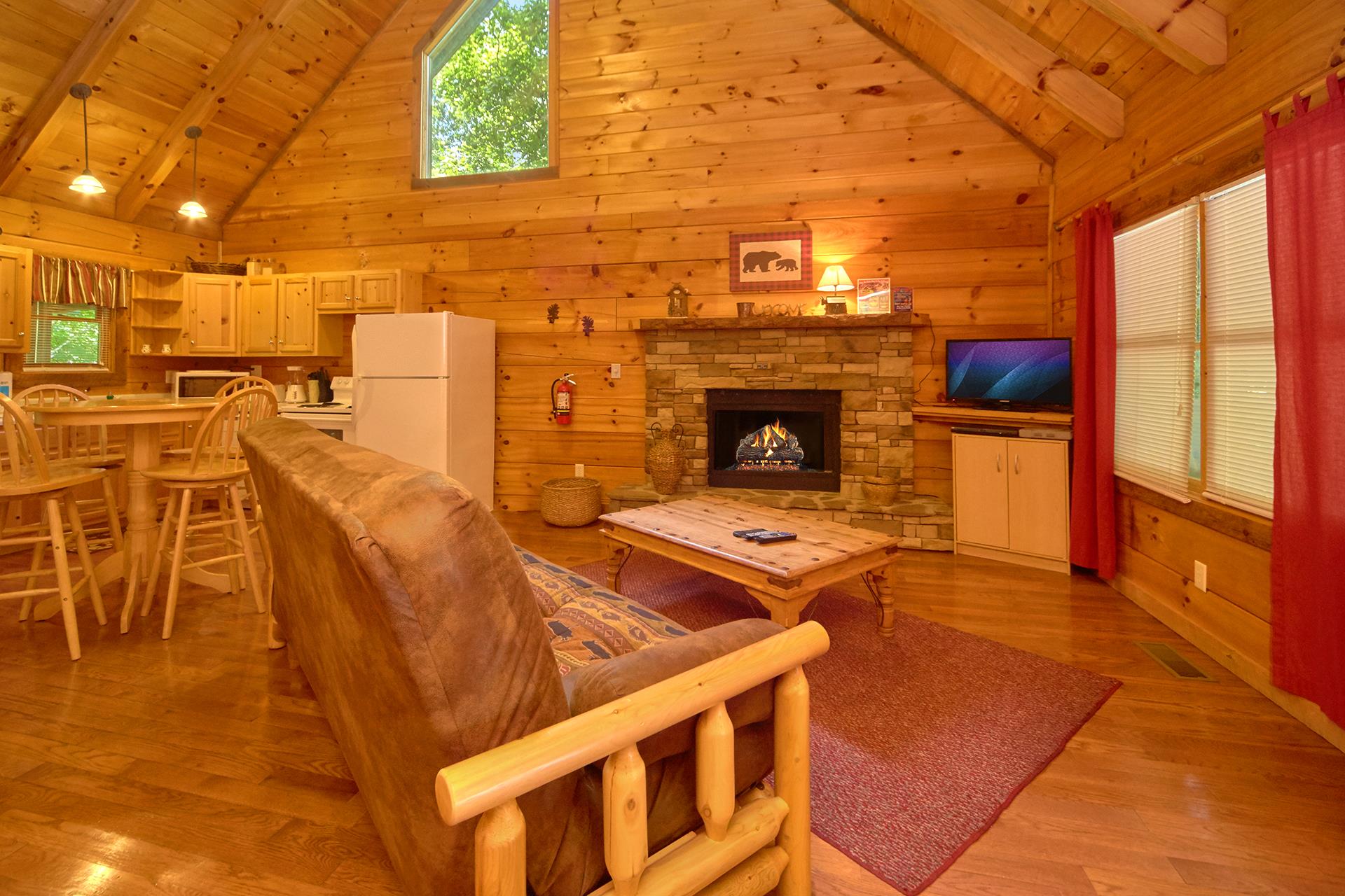 Living room with futon, fireplace, and TV at Wild Crush, a 1 bedroom cabin rental located in Pigeon Forge