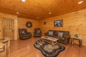 Sofa, two recliners, and video game in the lower living room at Js Hideaway, a 4 bedroom cabin rental located in Pigeon Forge