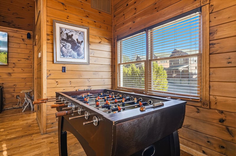 Challenge friends to a spirited foosball match in this rustic game room with natural wood accents and mountain views through large windows.