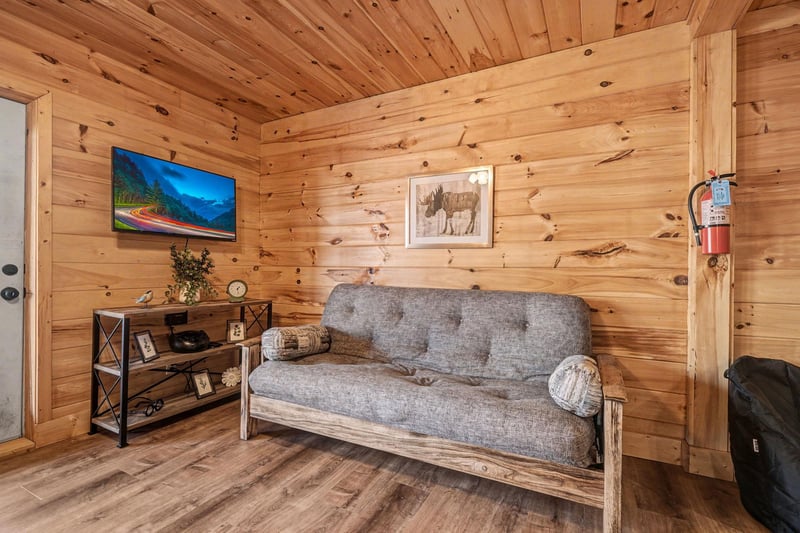 Unwind in your cozy cabin living room surrounded by warm cedar walls and rustic charm.