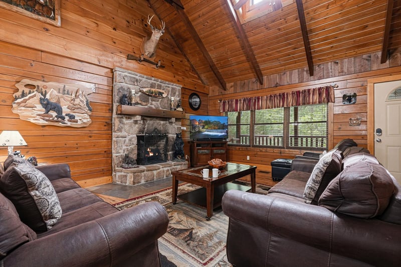 Settle into plush leather sofas beside a stone fireplace under cathedral ceilings with natural wood beams. Large windows bring in forest views and daylight.