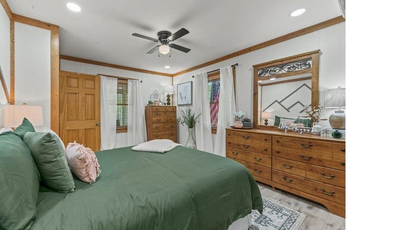 Drift into restful sleep in your cozy bedroom, where warm wood accents and soft green linens create a peaceful sanctuary.