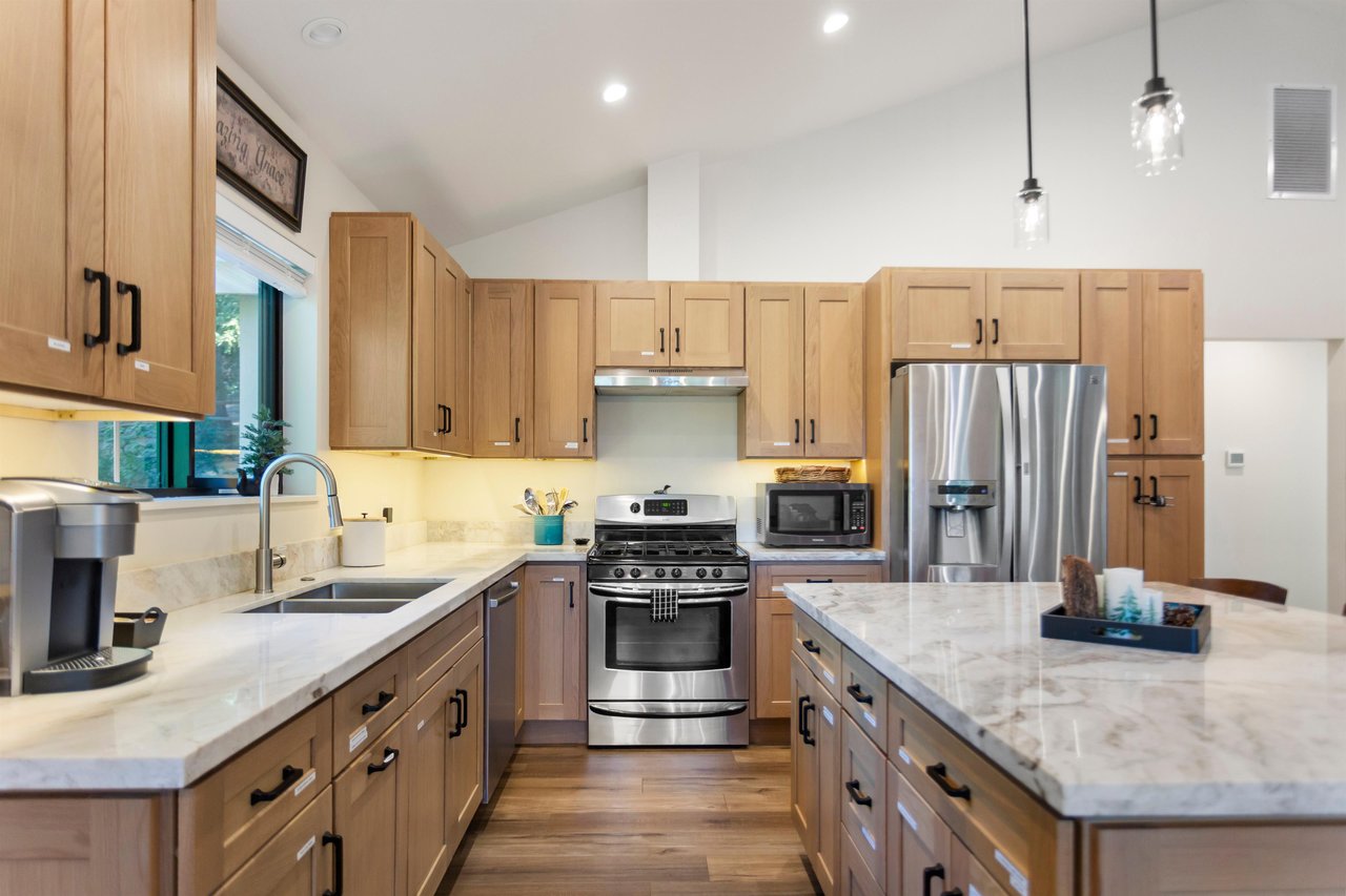 Full kitchen upstairs with stainless steel appliances, coffee station and large island.