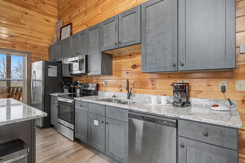 Your fully equipped kitchen features modern appliances, granite counters, and rustic wood walls perfect for preparing meals.