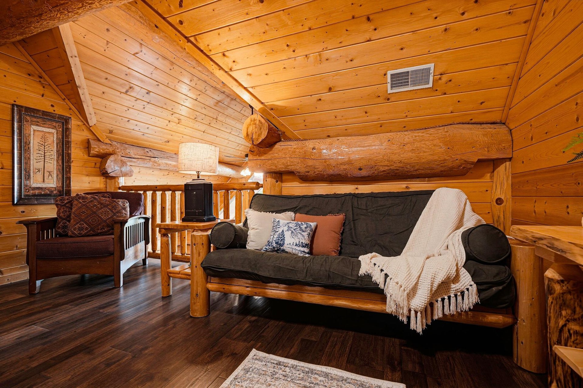 Unwind in your cozy loft with handcrafted log furnishings, warm wood walls, and rustic charm that invites you to relax after a day of adventure.