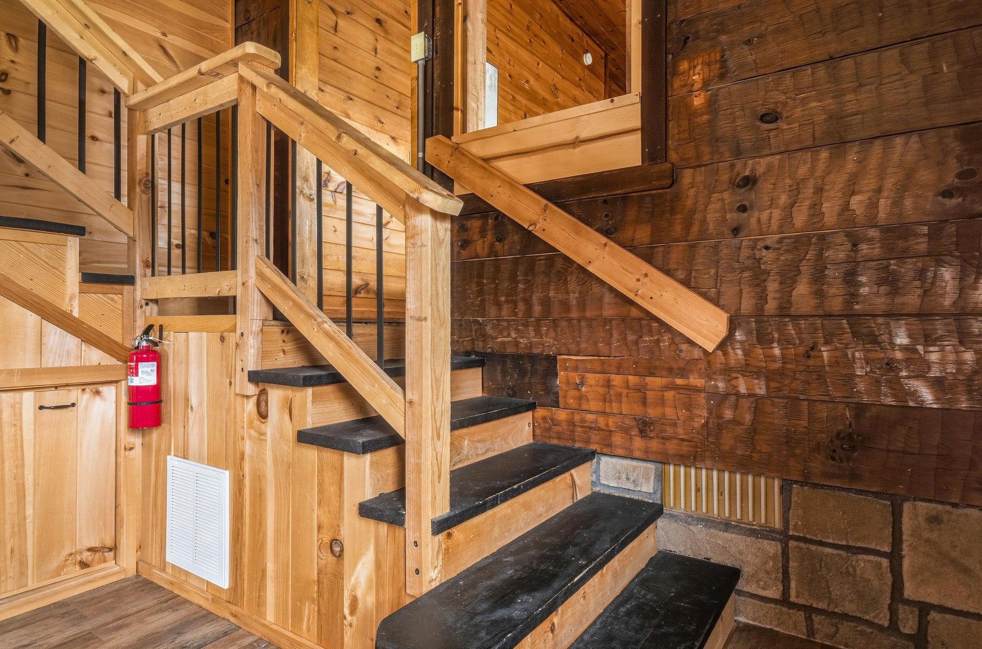 Rich wood tones and handcrafted details surround you at every turn, from the polished staircase to the warm timber walls and ceilings that create a cozy, cabinlike atmosphere.
