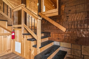 Rich wood tones and handcrafted details surround you at every turn, from the polished staircase to the warm timber walls and ceilings that create a cozy, cabinlike atmosphere.