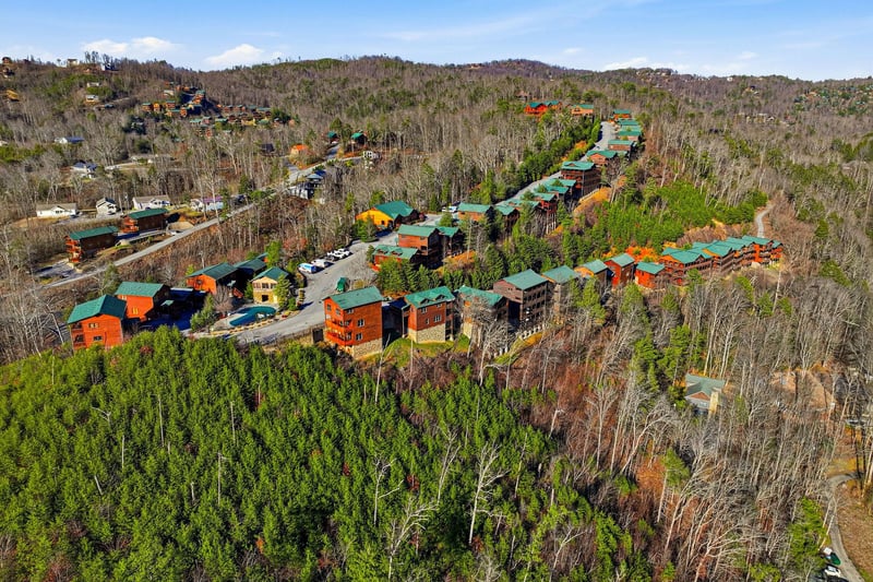 Aerial view of a mountain resort community nestled among rolling forested hills and winding roads.