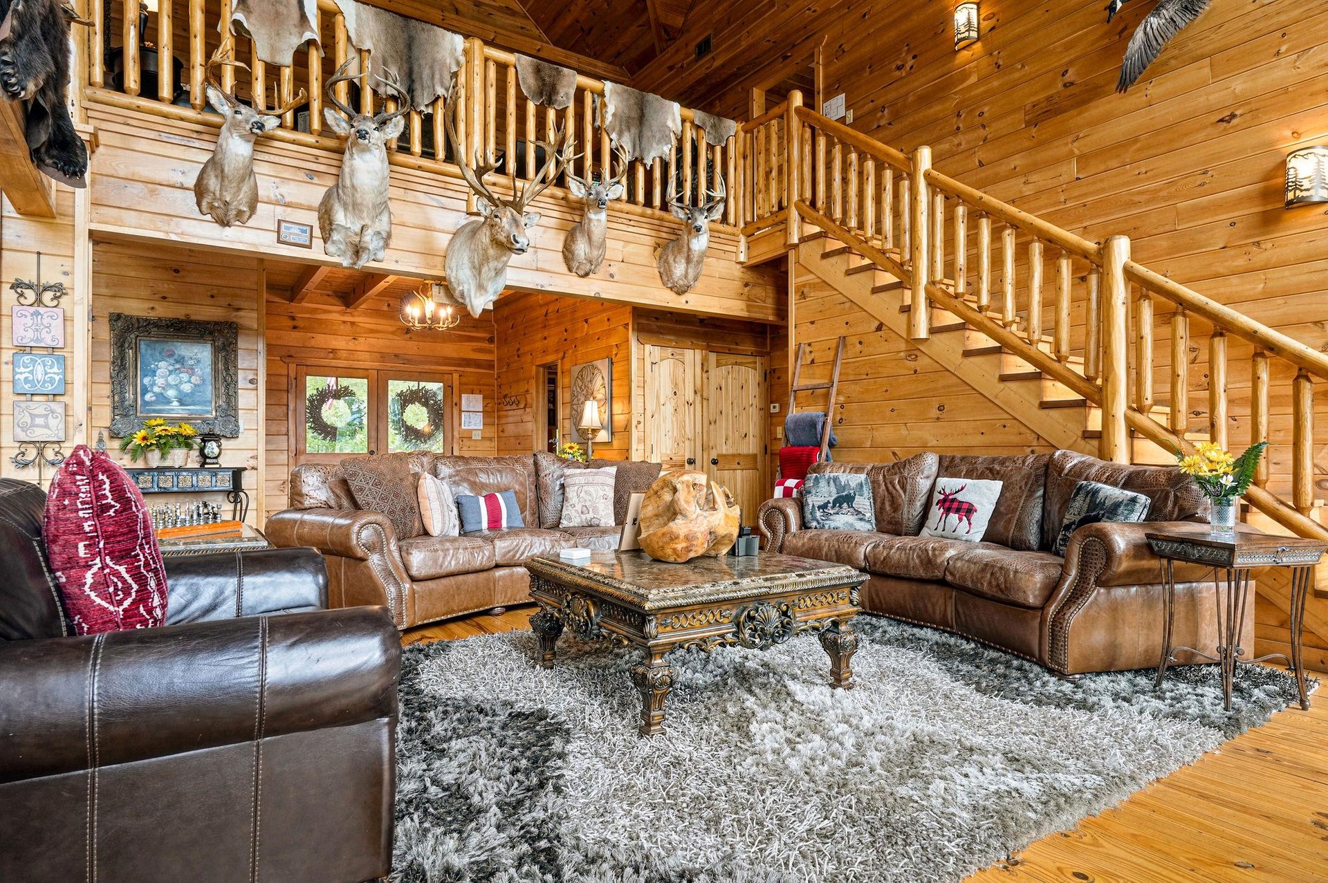 Rustic elegance meets mountain lodge charm in this inviting great room. Rich leather seating and soaring timber ceilings create the perfect retreat after your adventures.