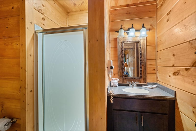 Step in shower with divider wall to single vanity sink