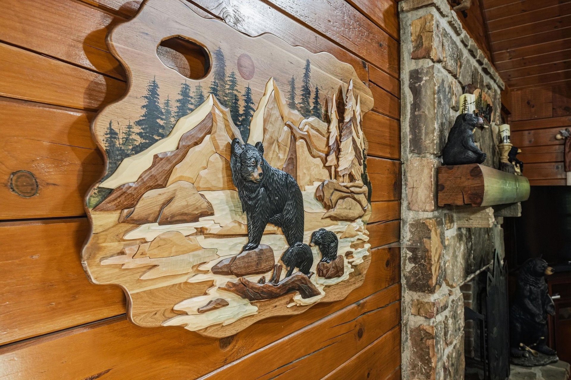 Rustic mountain charm greets you with custom wood carvings and a stacked stone fireplace—cozy craftsmanship that makes this cabin feel like your own alpine retreat.
