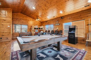 Your game room awaits with a fullsized pool table, arcade fun, cozy theater seating, and warm woodpaneled charm—perfect for friendly competition and laughter.