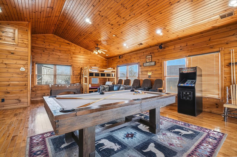 Your game room awaits with a fullsized pool table, arcade fun, cozy theater seating, and warm woodpaneled charm—perfect for friendly competition and laughter.