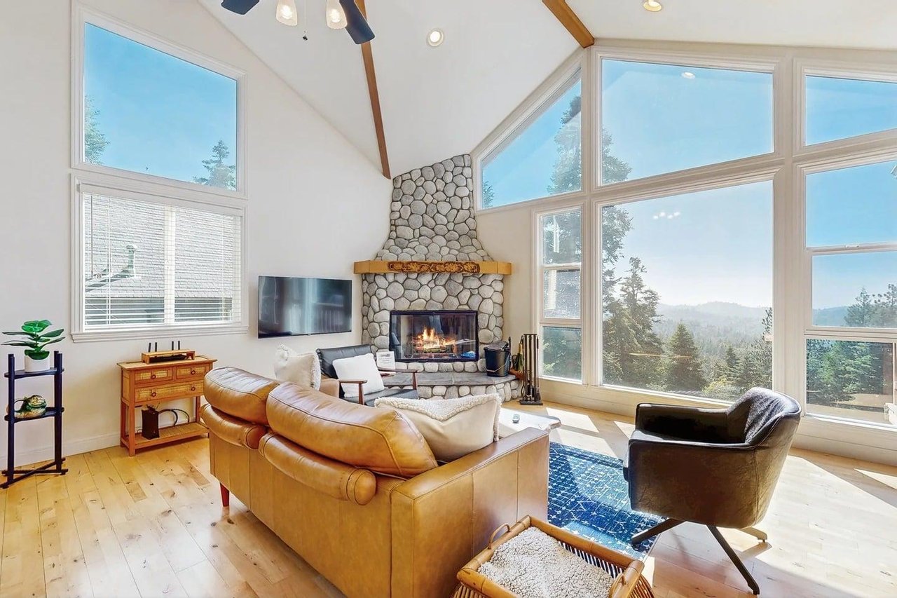 Large stone fireplace, ample seating, and easy access to the kitchen and dining area.