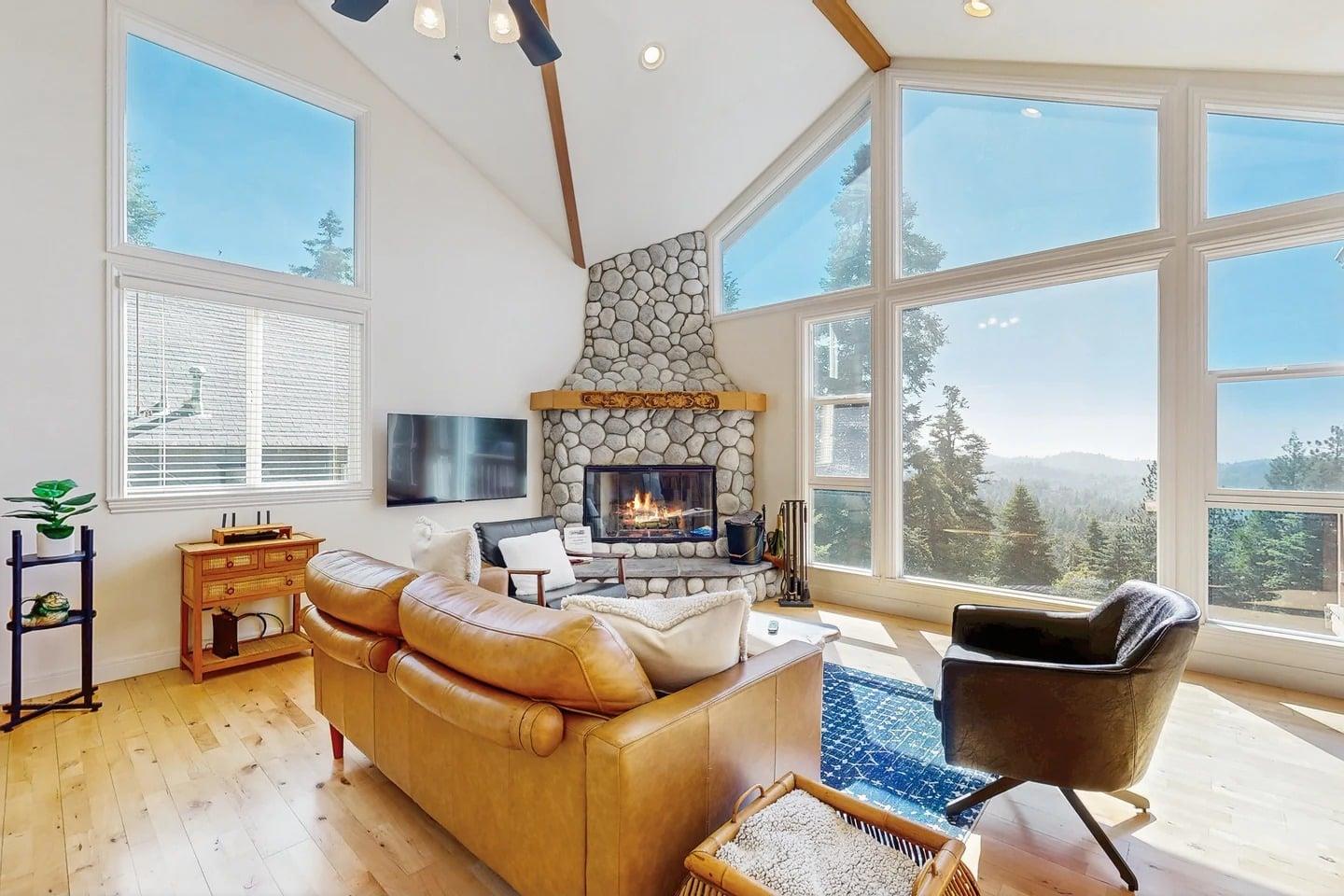 Large stone fireplace, ample seating, and easy access to the kitchen and dining area.