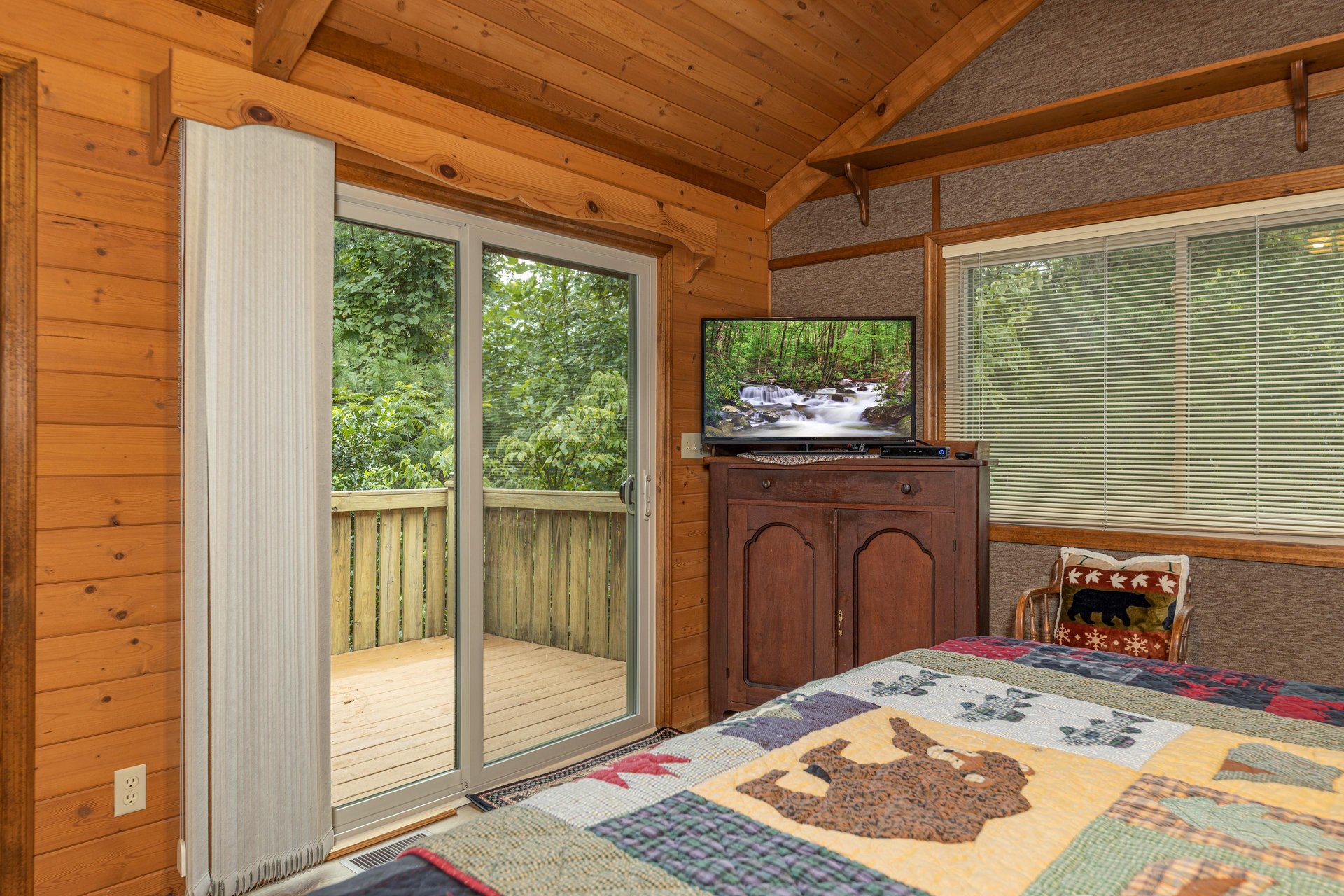 TV and deck access in a bedroom at Cubs Crib, a 3 bedroom cabin rental located in Gatlinburg