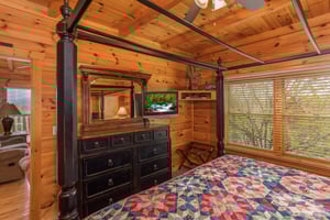 Bedroom with a canopy bed, dresser, and TV at Howlin in the Smokies, a 2 bedroom cabin rental located in Pigeon Forge
