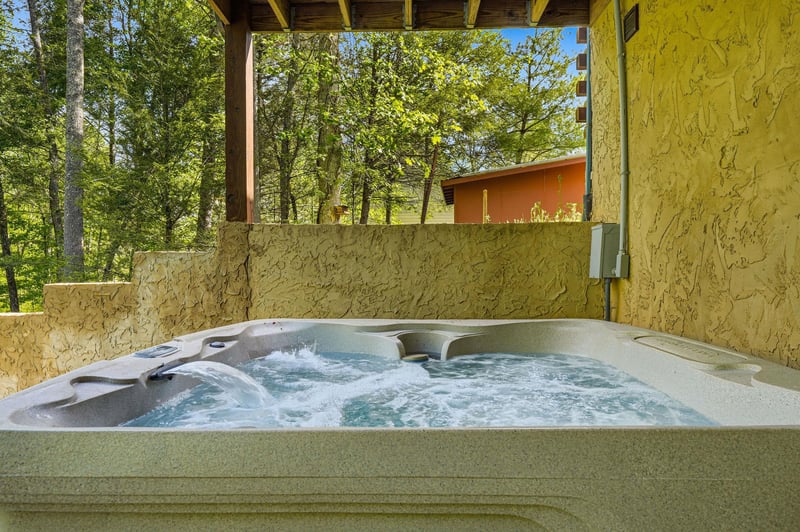 Sink into bubbling bliss in your private hot tub, surrounded by towering trees and peaceful forest views.