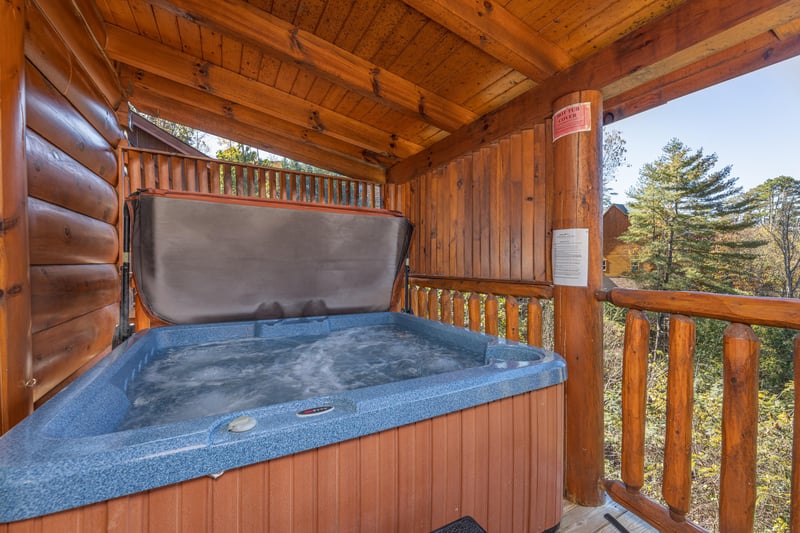 Hot tub on a covered deck at Bears Dont Bluff, a 3 bedroom cabin rental located in Pigeon Forge