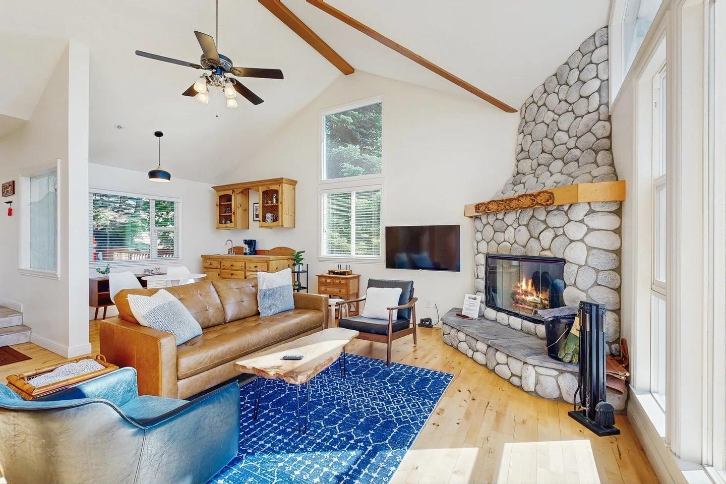 Large stone fireplace, ample seating, and easy access to the kitchen and dining area.