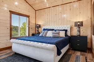 Relax in your cozy retreat, where natural wood walls and soft lighting create a warm, welcoming atmosphere. Sink into plush bedding and enjoy the serene green views through the window.