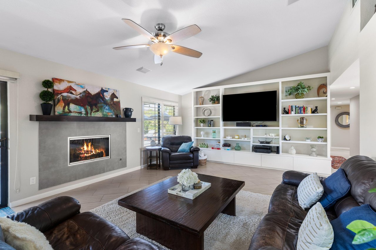 Spacious living room with a gas fireplace, flatscreen TV, and sliding doors out to the back patio.
