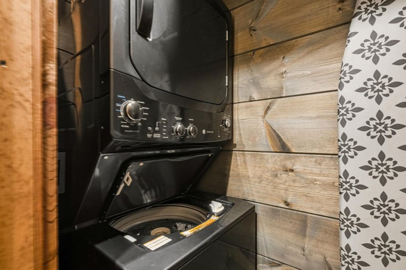 Keep your wardrobe fresh during your stay with this convenient inunit washer and dryer combo, set against charming rustic wood walls for a cozy, homeawayfromhome feel.