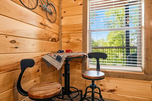 Your cozy cabin corner features rustic charm with a perfect workspace and bike storage, all while enjoying peaceful tree views.