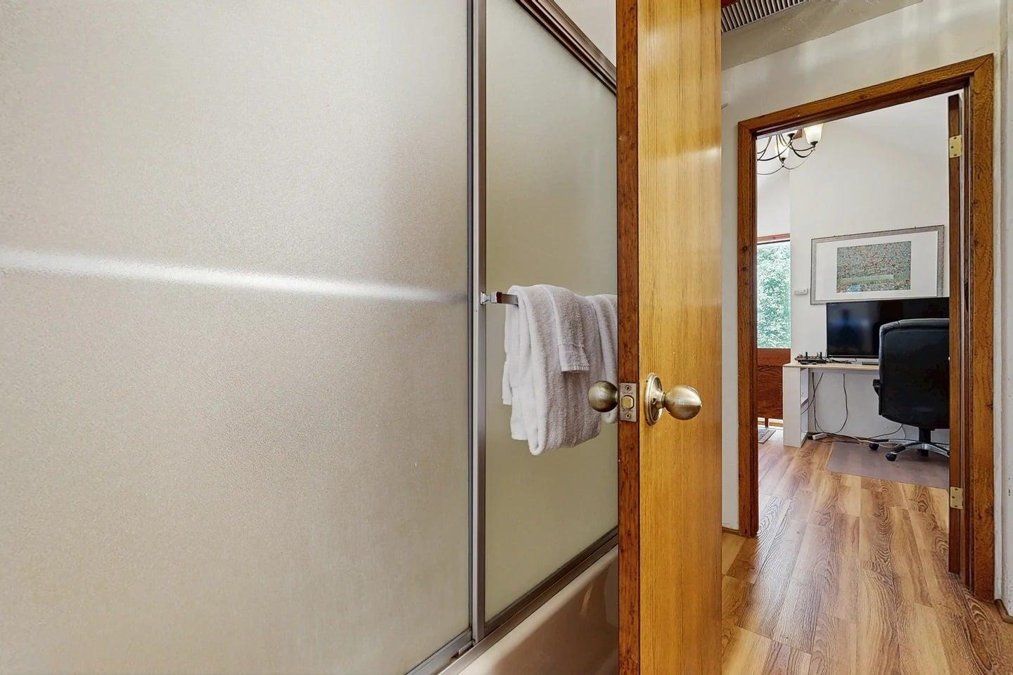 The upstairs bathroom, shared between the primary and second bedrooms, features a glassenclosed shower and tub just steps from both rooms.