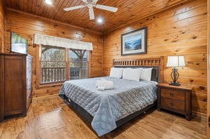 Unwind in your cozy bedroom featuring warm wood paneling, a plush bed, and a ceiling fan to keep you comfortable yearround. Fresh towels and peaceful natural light complete the relaxing retreat.