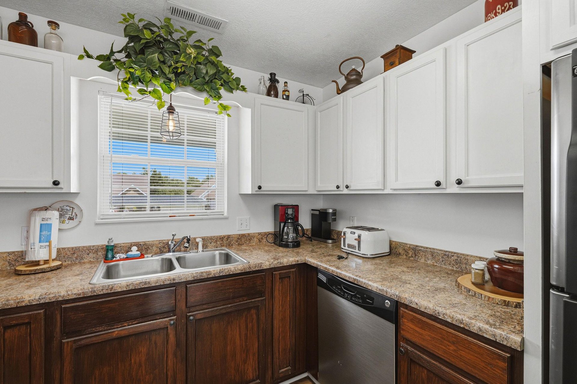 Your fully equipped kitchen awaits with granite counters, modern appliances, and a cheerful window view—perfect for brewing morning coffee or preparing meals at home.