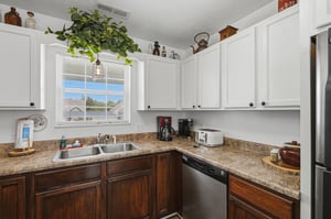 Your fully equipped kitchen awaits with granite counters, modern appliances, and a cheerful window view—perfect for brewing morning coffee or preparing meals at home.