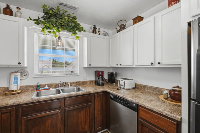 Your fully equipped kitchen awaits with granite counters, modern appliances, and a cheerful window view—perfect for brewing morning coffee or preparing meals at home.
